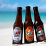 Three bottles of beer standing in the sand at the beach