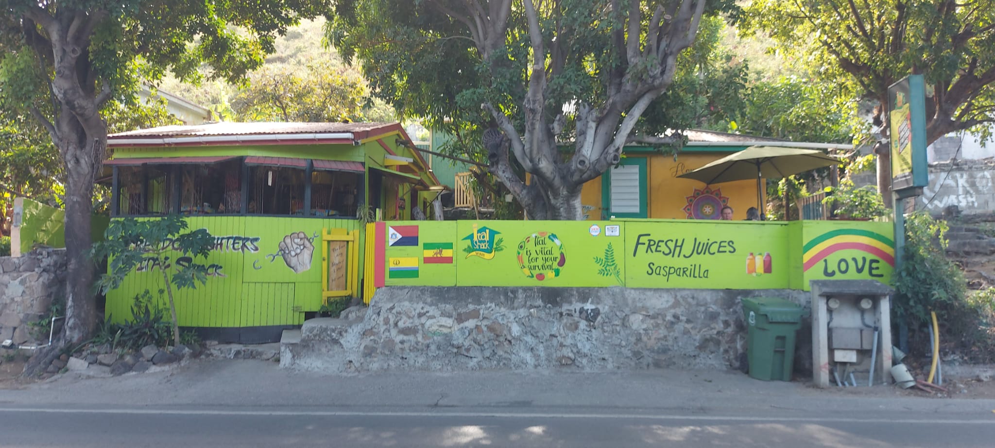 outlook of the ital shak restaurant; green and yellow cabins with text on them