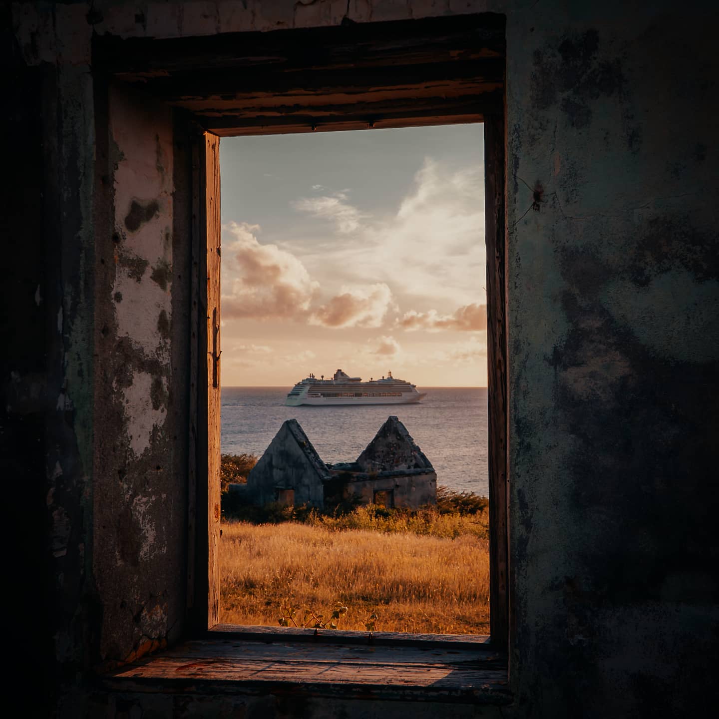 A picture of a cruise ship trough a window of Fort Amsterdam