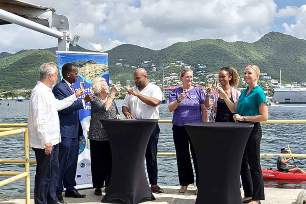 Beatrix with a few others cheering with some wine on a pier