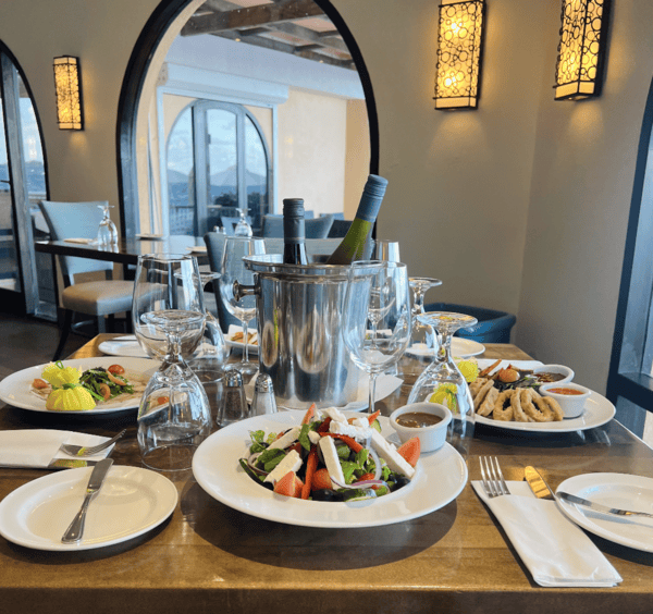 A table set with food and wine at Infinity Restaurant in Oyster Bay Beach Resort