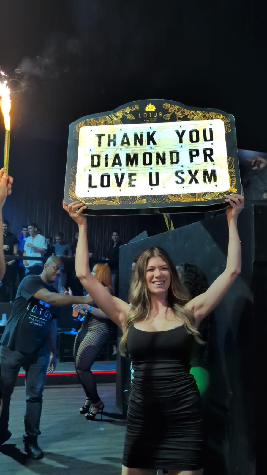 A girl with a light board which says 'tank you diamond pr love u sxm'