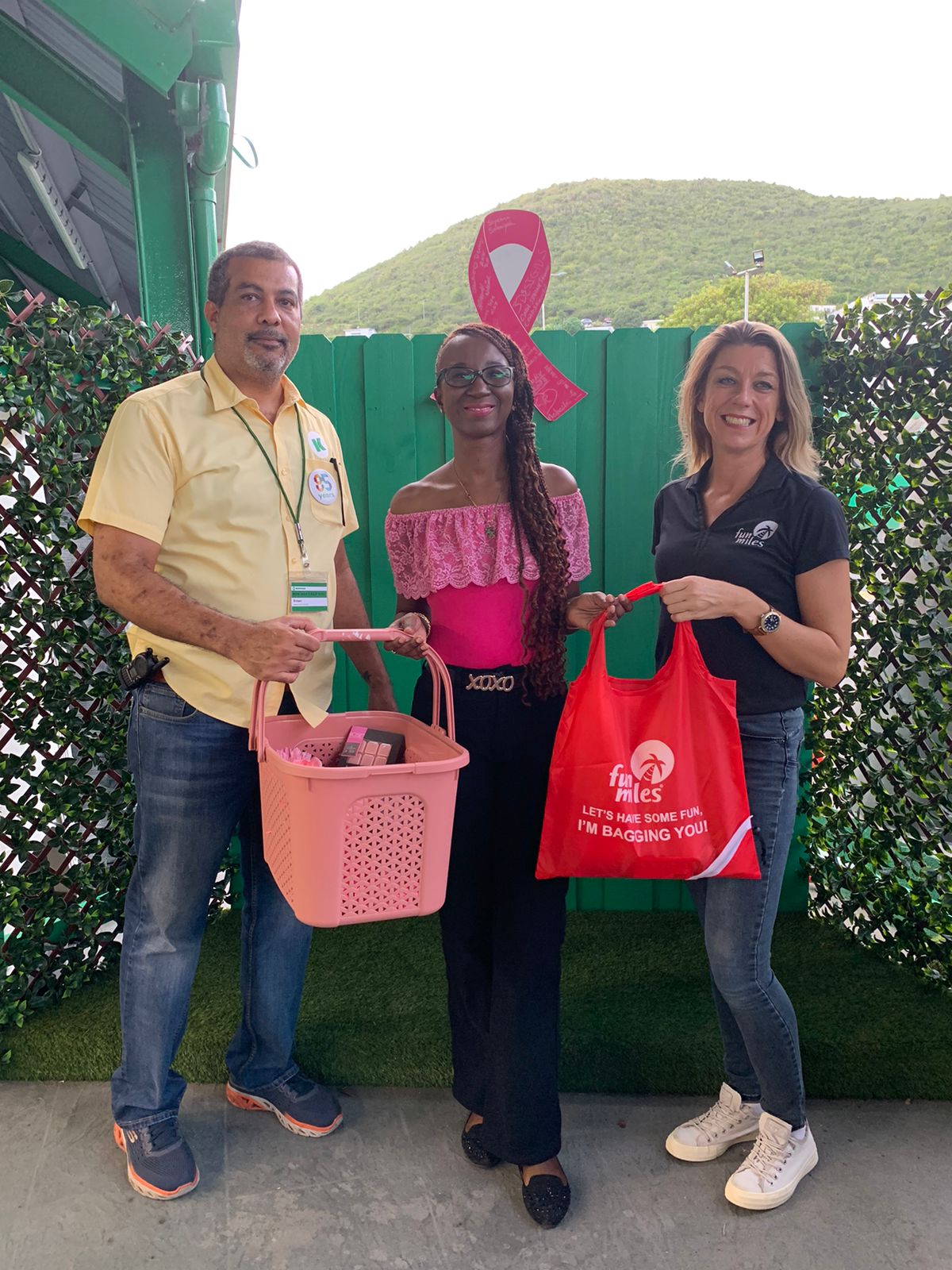 Three people standing at Kooyman Pink Wall “Pink Positive” Campaign