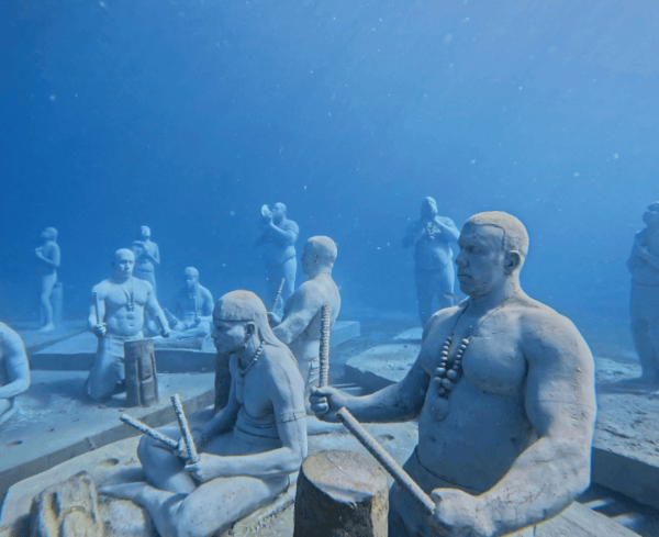 Under SXM statues sitting at the bottom of Divi Little Beach Bay