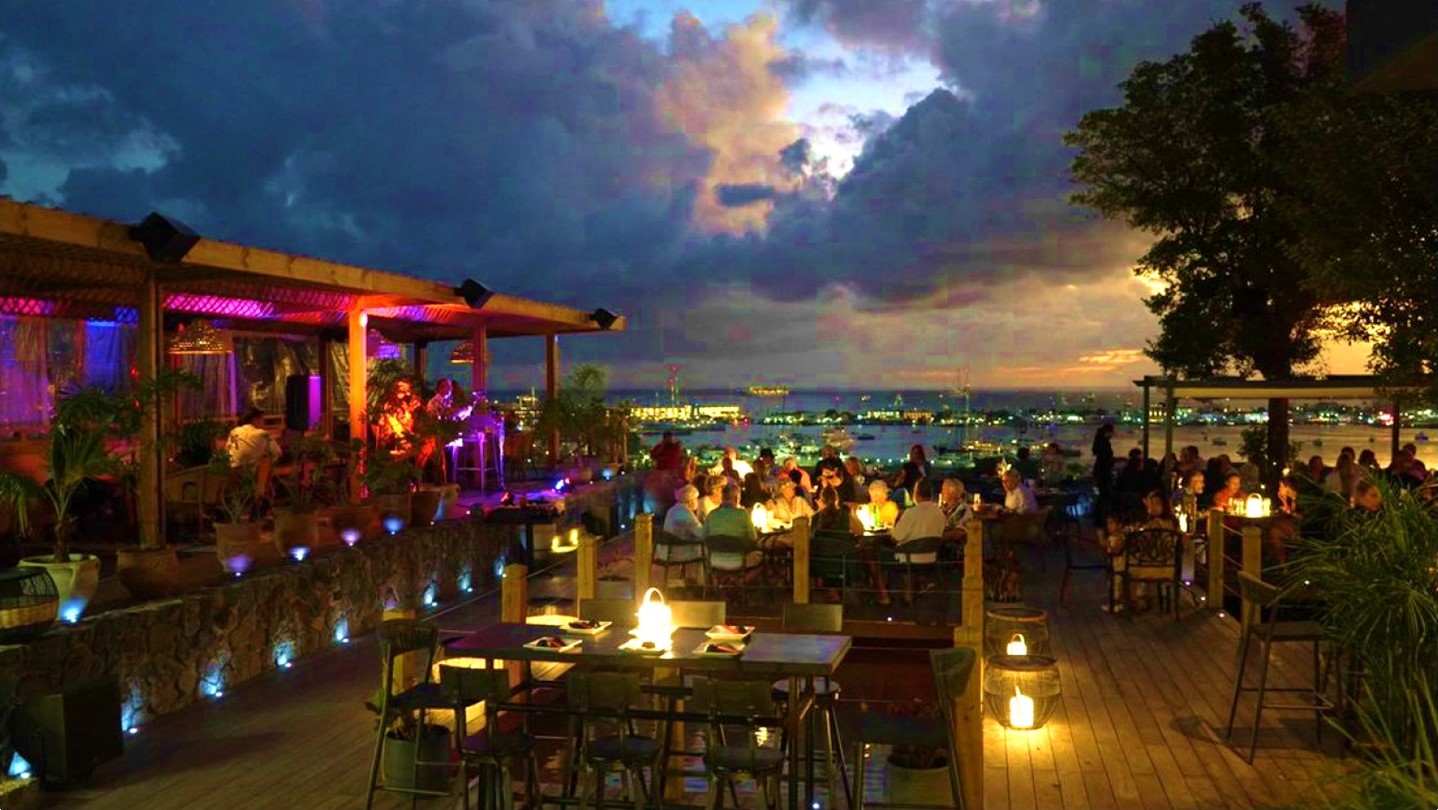 evening at bamboo house where people are sitting outside and having drinks/dinner