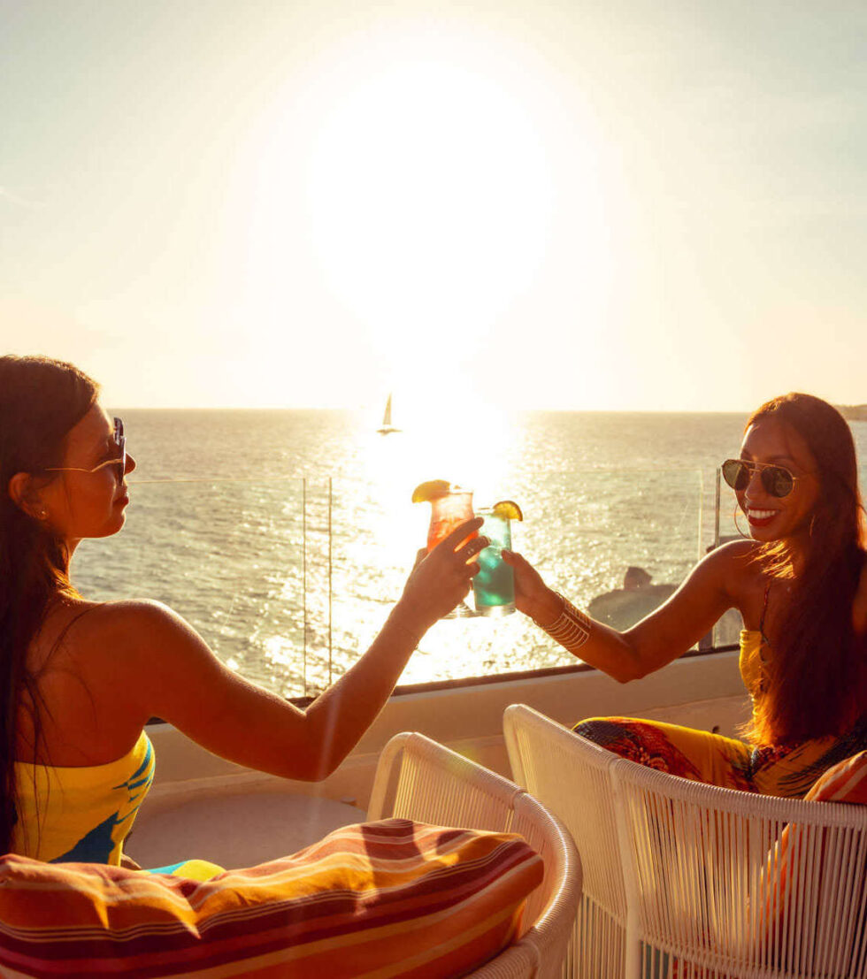 2 girls cheersing at the rooftop terrace of sonesta: cloud 9